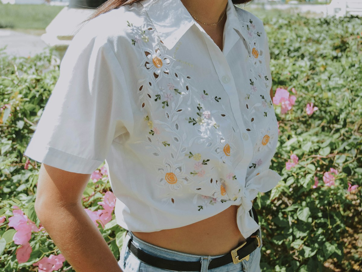 Blusa branca bordada com flores, amarrada na cintura